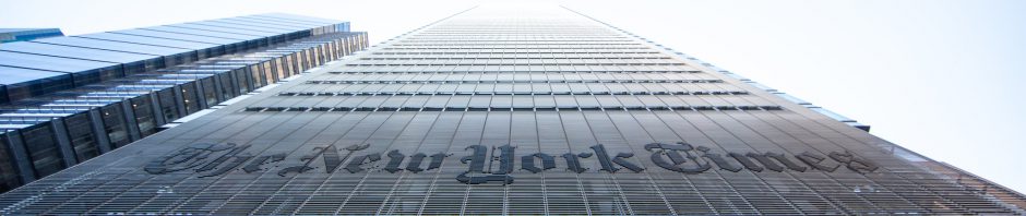 New York Times building photo taken from below, showing title on exterior with forced perspective heading to infinity